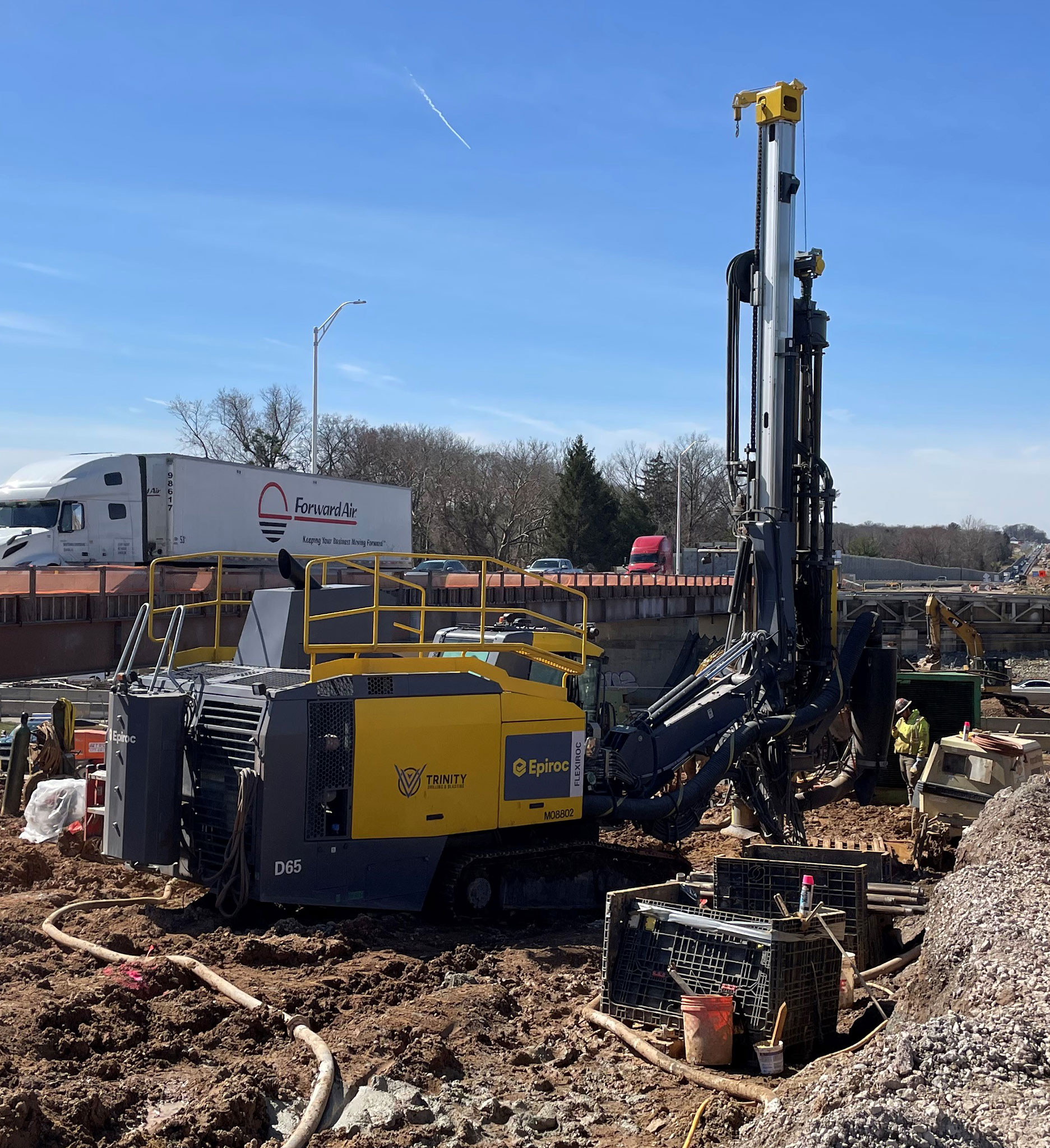 PTC-Drilling Large drilling equipment next to highway on jobsite.